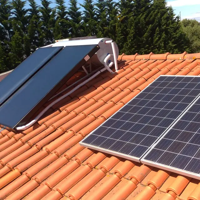 Telhado de telha com um termossifão e painéis fotovoltaicos lado a lado.